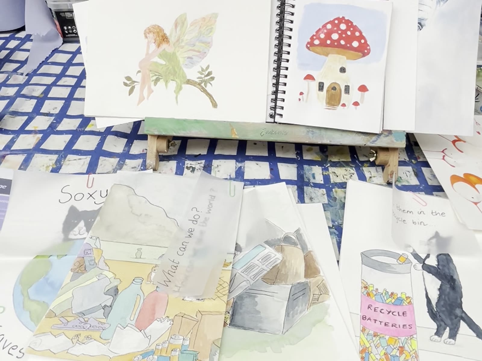 Character illustrations and a sketchbook on the workshop table
