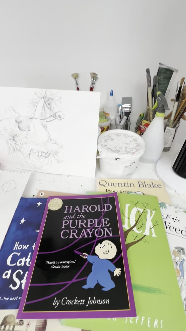 Picture books including Harold and the Purple Crayon and Stuck, open on an easel