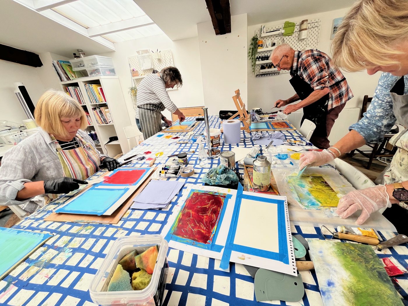 The Thursday Art Club round the long table, gloves on, working cold wax into the first mark-making sheets