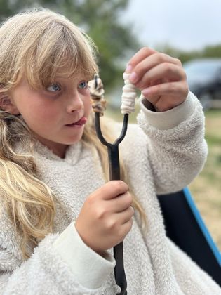 A marshmallow on the toasting fork she forged herself
