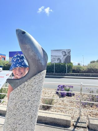 Amélie by the sculpture, the photography festival board behind her