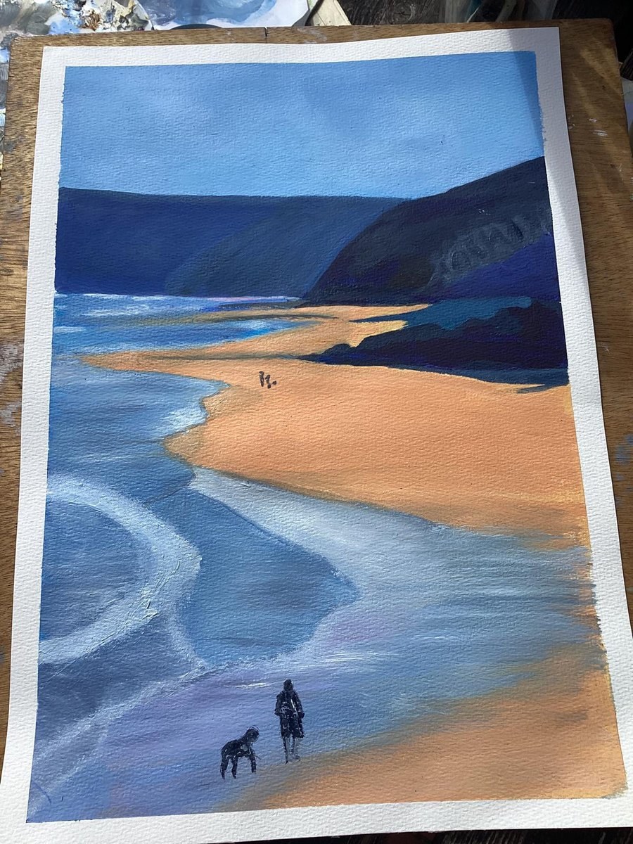 A figure and a dog on wet sand at low tide, headland beyond