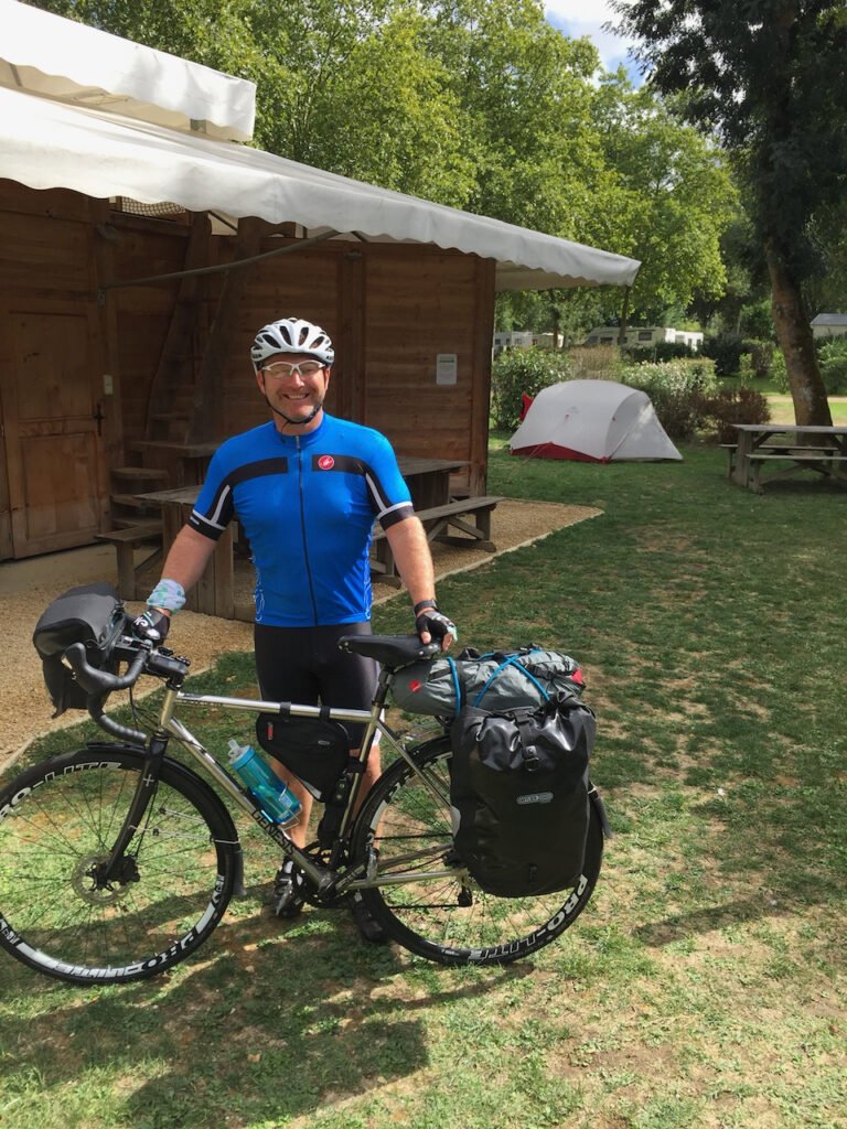 Damian standing with his loaded touring bicycle